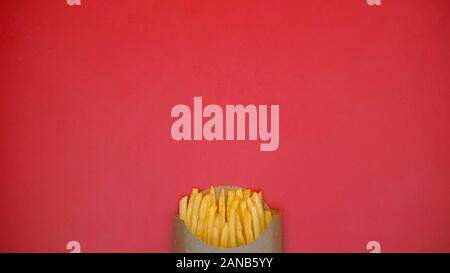 Francese-patate fritte in scatola di cartone su sfondo rosso, take away snack, prodotti alimentari Foto Stock