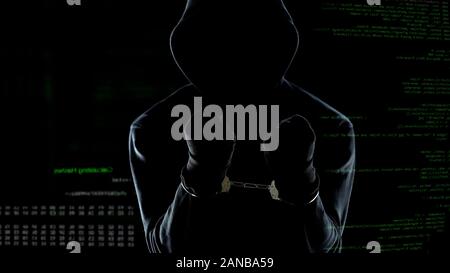 Silhouette di ammanettato anonimo in piedi di fronte a animato di codice per computer Foto Stock