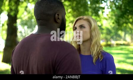 Donna addolorata guardando afro-americano, si rompono a causa di pregiudizi Foto Stock