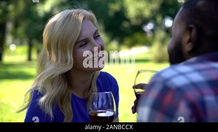 Gioiosa giovane tostatura e bere il vino nel parco romantico, data e picnic Foto Stock