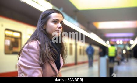 Giovane donna che guarda al treno in partenza, in ritardo per il lavoro, occasione persa nozione Foto Stock