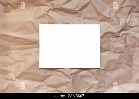 Crumpled craft carta marrone lo sfondo con il foglio bianco in mezzo. Copia dello spazio. Orizzontale. DIY, artigianato, torna a scuola, ecologia, plastica libera conce Foto Stock