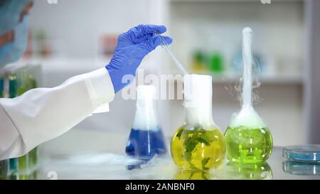 Biochimico tenendo giallo sostanza organica campione dal pallone di estrazione di piante Foto Stock