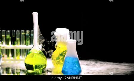 Palloni da laboratorio con sostanze chimiche emettendo fumo, esperimenti e innovazioni Foto Stock