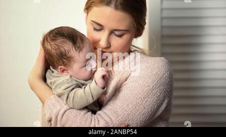 Babysitter tenendo poco adorabile neonato in orfanotrofio, adozione nella nuova famiglia Foto Stock