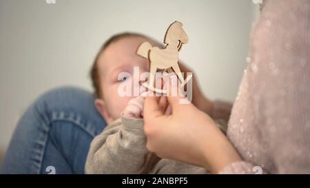 Mostra femmina cavallo di legno figura al neonato Bambino, sviluppo nella prima infanzia Foto Stock