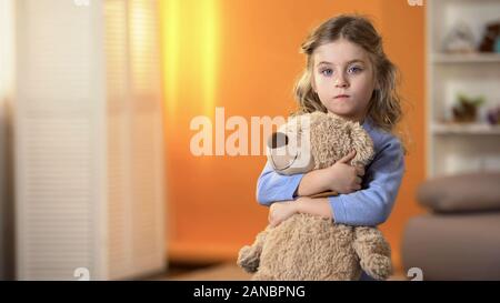 Abbandonato sconvolto curly ragazza con orsetto preferito sensazione triste in orfanotrofio Foto Stock