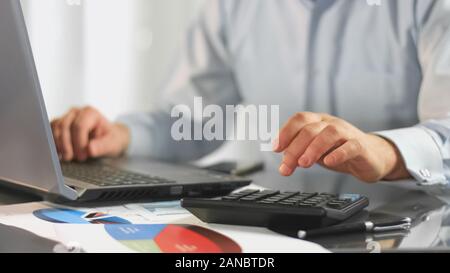 Imprenditore notebook di lavoro calcolo dati fiscali per relazione contabile della società Foto Stock