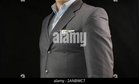 Di dollari di imprenditore suit pocket, risparmiare denaro, reddito o il concetto di corruzione Foto Stock