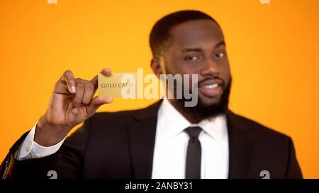 Moda afro-americano in abito formale che mostra la carta oro, club membership Foto Stock