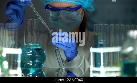 Ricercatore di liquido di gocciolamento in provetta con il campione di acqua, controllare il livello del PH Foto Stock