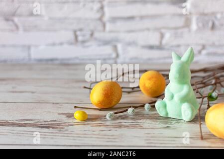 Colorato in giallo le uova di Pasqua con la divertente coniglietto di Pasqua su un tavolo di legno. Felice Pasqua tempo. Creative decorazione di Pasqua. Copia dello spazio. Foto Stock