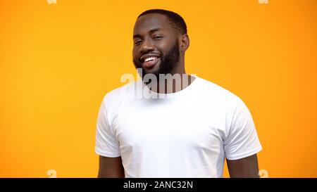 Allegro afro-americano di uomo sorridente in telecamera isolata su sfondo giallo Foto Stock