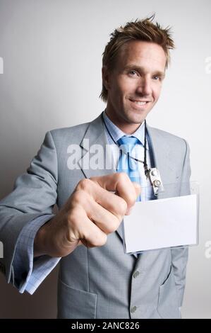 Imprenditore allegro sorridente come egli detiene il suo nome vuoto tag Foto Stock