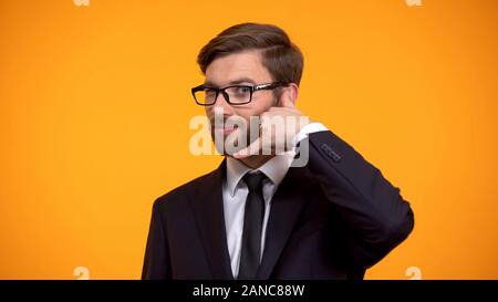 Uomo in tuta che mostra call me gesto, assistenza clienti, operatore di call center Foto Stock