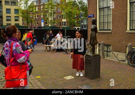 Amsterdam, Olanda, Agosto 2019. La statua di Anne Frank è meta di molti turisti: molti posano per una foto ricordo con lei. Esso si trova a b Foto Stock