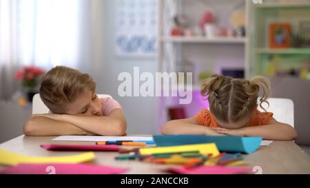 Stanchi i bambini ad addormentarsi seduto alla scrivania, estenuante dopo-scuola educazione Foto Stock