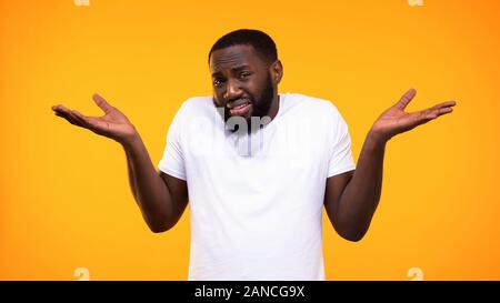 Confuso afro-americano che non mostrano alcuna idea gesto, problema esitazione, scelta Foto Stock