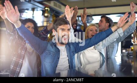 Entusiasti appassionati di sport battendo le mani nel bar, allietarla team, celebrando la vittoria Foto Stock