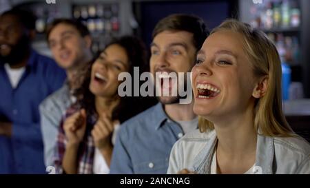 Estremamente felice ragazza godendo di corrispondere con gli amici, celebrando la vittoria del team Foto Stock