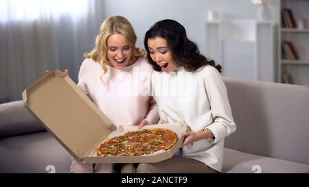 Due donne divertimento a casa, apertura Scatola pizza, Consegna del cibo, home party Foto Stock