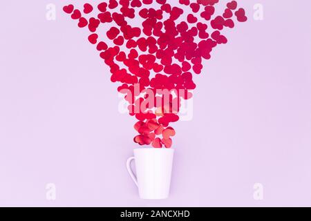 Porcellana Bianca la tazza con il glitter cuore coriandoli. Il giorno di San Valentino del concetto. Trendy in stile minimalista piatto design laici dello sfondo. Posizione orizzontale Foto Stock