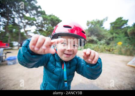 Bambino che gioca all'aperto con il casco. Foto Stock