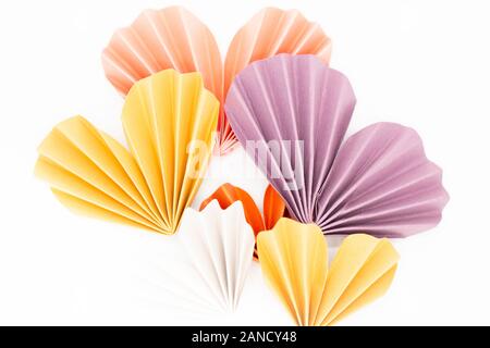 Carta color pastello origami cuori disposizione su sfondo bianco Foto Stock