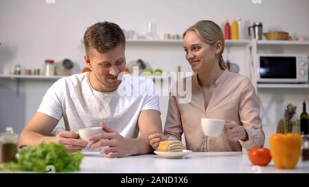 Allegro uomo e donna con tea time con torta dolce in cucina, stare insieme Foto Stock