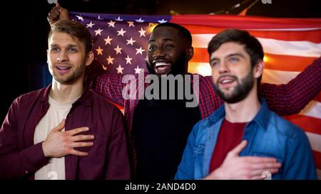 Patriottici fan americano il tifo per il team, cantando l'inno e sventola bandiera in pub Foto Stock