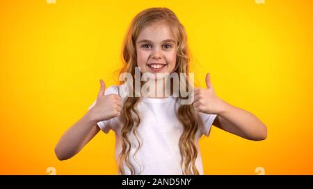 Emotivo girl teen facendo doppio pollice in su, estremamente soddisfatto bambino, promo Foto Stock
