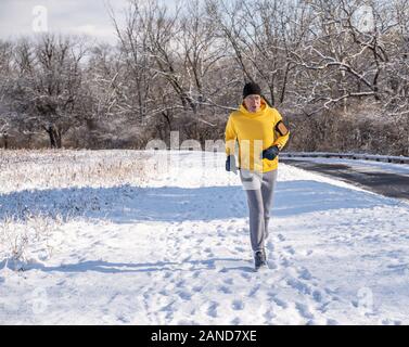 Berks County, Pennsylvania, 8 Gennaio 2020: Senior uomo in esecuzione sul sentiero innevato Foto Stock