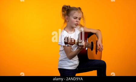 Adorabile ragazza teen fingere di suonare la chitarra, sogno di diventare una famosa rock star Foto Stock