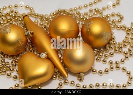 Decorazioni natalizie di colore oro su sfondo bianco Foto Stock