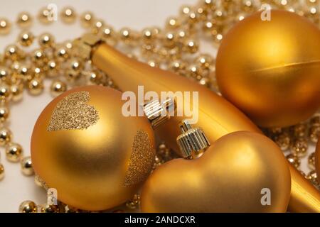 Decorazioni natalizie di colore oro su sfondo bianco Foto Stock