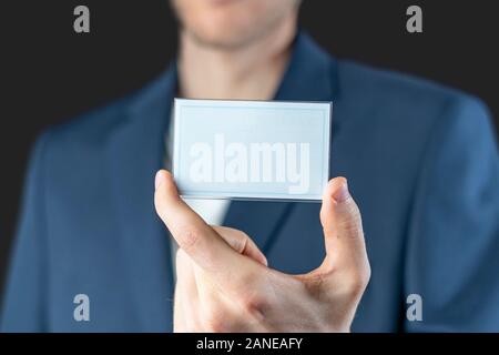 Un imprenditore in possesso di un badge di vuoto con spazio copia mockup, Autorizzazione e identificazione Foto Stock