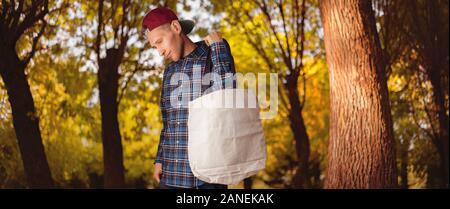 Giovani hipster tenendo un cotton textile sacchetto contro la parete di sfondo, salvare il pianeta ambiente Foto Stock