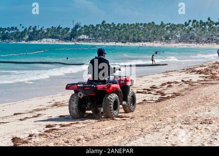 Una guardia di sicurezza turistica specializzata Corps {CESTUR}, pattuglie costiere il nastro su un veicolo speciale Punta Cana , Repubblica Dominicana Foto Stock