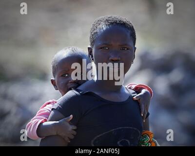 Janjanbureh, Gambia - Gennaio 6, 2019: Sconosciuto poveri bambini africani fuori nel sole bruciante lavorando Foto Stock