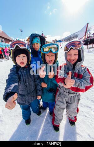 Sheregesh, Mountain Shoria, Kemerovo Regione, Russia - aprile 08, 2019 : Quattro ragazzi piccoli nelle maschere da sci e overals sul pendio Foto Stock