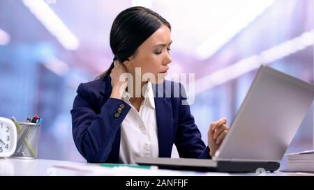 Stanco business donna che soffrono di dolore al collo seduta portatile anteriore, la cura della salute Foto Stock