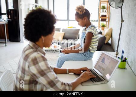 Occupato a lavorare la madre di non avere tempo per il suo bambino Foto Stock