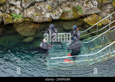 SILFRA, Islanda - 20 Maggio 2019: i subacquei e gli amanti dello snorkelling preparazione di entrare in acqua a Silfra rift, il luogo dove Eurasian e l'Americano Foto Stock