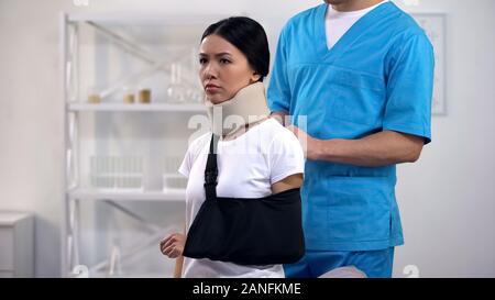 Maschio professionale chirurgo braccio di fissaggio imbracatura sconvolto paziente in schiuma collare cervicale Foto Stock