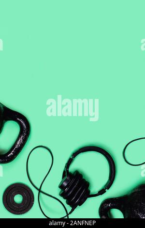 Foto sportive. Kettlebells e manubri di menta su sfondo verde. Appartamento laico, vista dall'alto, copia dello spazio. Foto Stock
