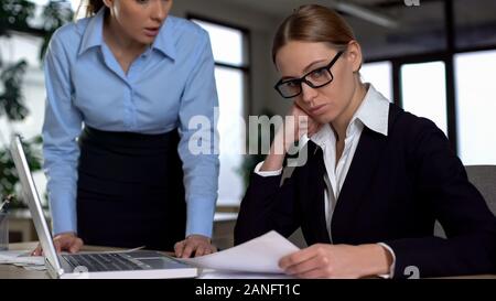 Il boss negativo scolding giovane dipendente per lavoro scadente, insoddisfatto con errori Foto Stock