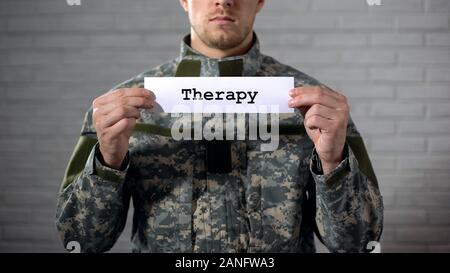La terapia parola scritta sul segno nelle mani del soldato maschio, assistenza medica Foto Stock