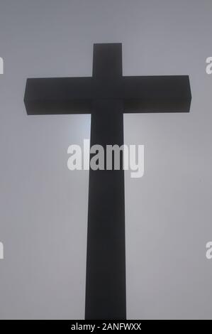 Silhouette di croce religiosa al centro della nebbia e situata sulla cima del monte Lema in Svizzera. Questo è un simbolo di speranza Foto Stock