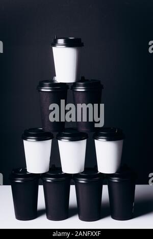 Bicchieri bianchi e neri per il caffè. Occhiali ecologici in cartone. Foto Stock