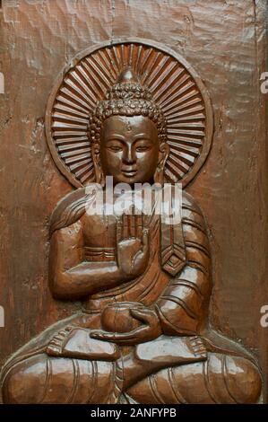 In prossimità di uno in legno intagliato testa di Buddha con un aura mistica intorno alla sua testa. Situato presso il nepalese Pagoda della Pace a Brisbane, South Bank Parklands Foto Stock